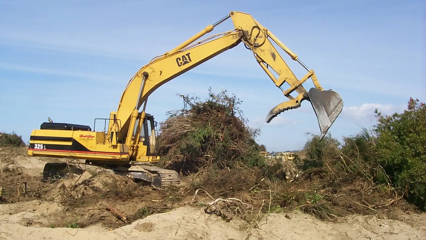 Excavator moving soil at an outdoor work site.
