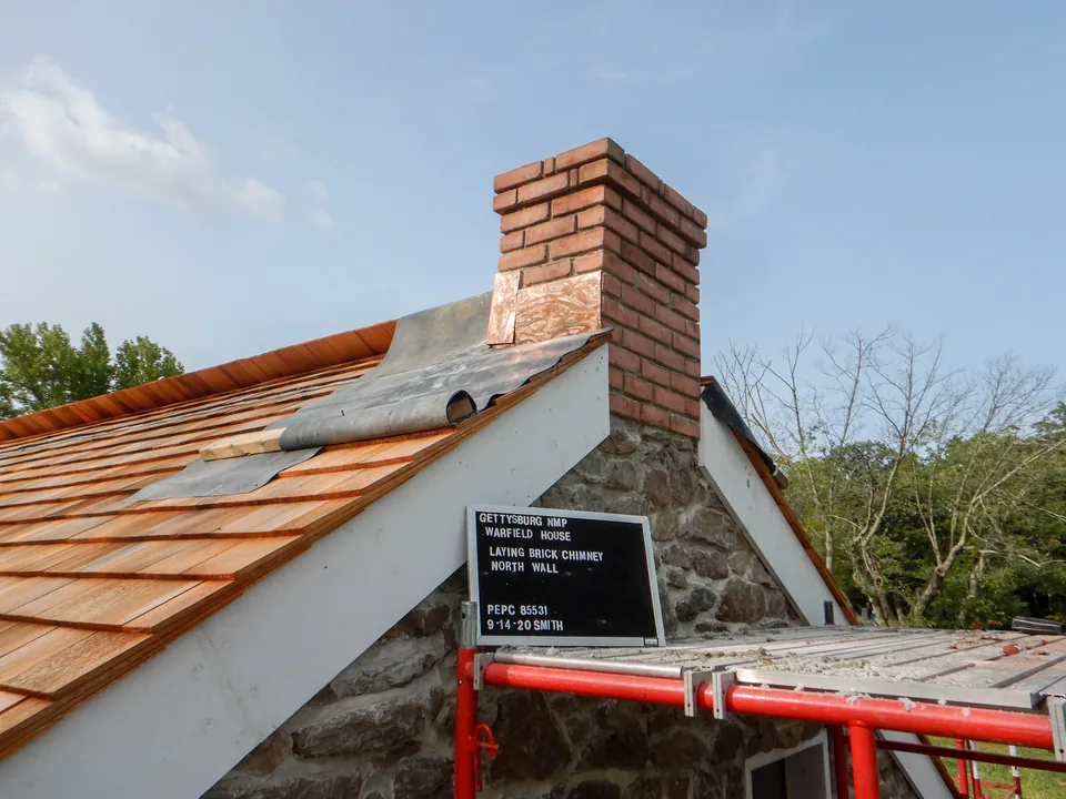 National Park Service preservationists completing a brick chimney reconstruction at the Warfield House in Gettysburg National Military Park.