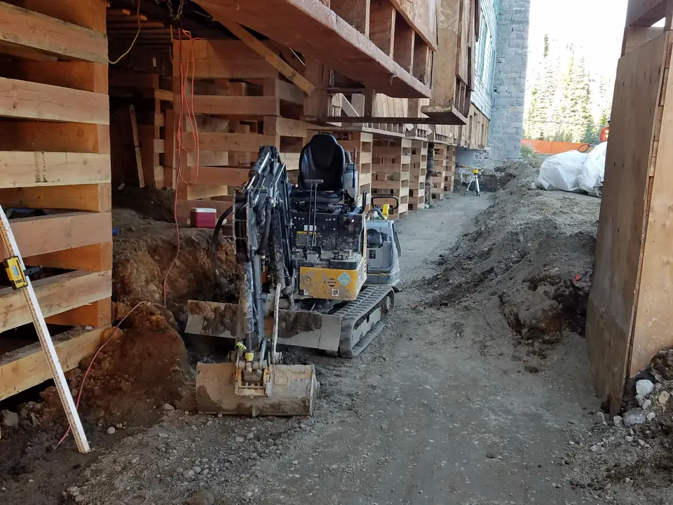 Large wood building temporarily supported above new foundation formwork during reconstruction.