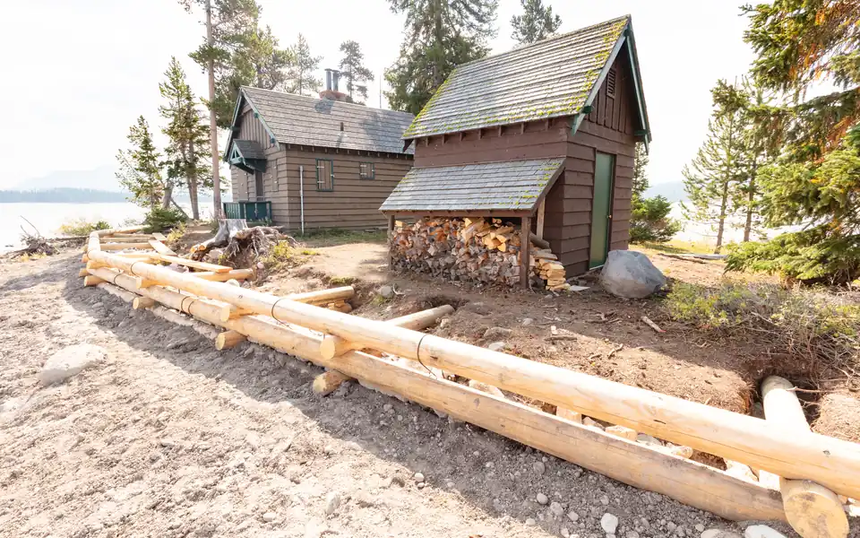 Retaining wall under construction with stone and drainage work visible.